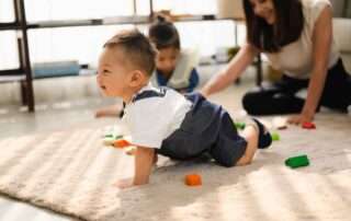 Toddler practicing crawling skills during early intervention occupational therapy session at OrbRom Center in Phnom Penh.