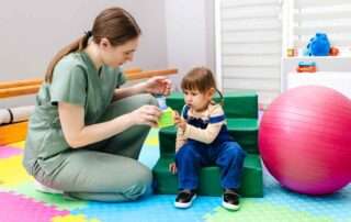 Therapist and toddler using colorful toys for early intervention occupational therapy at OrbRom Center in Phnom Penh
