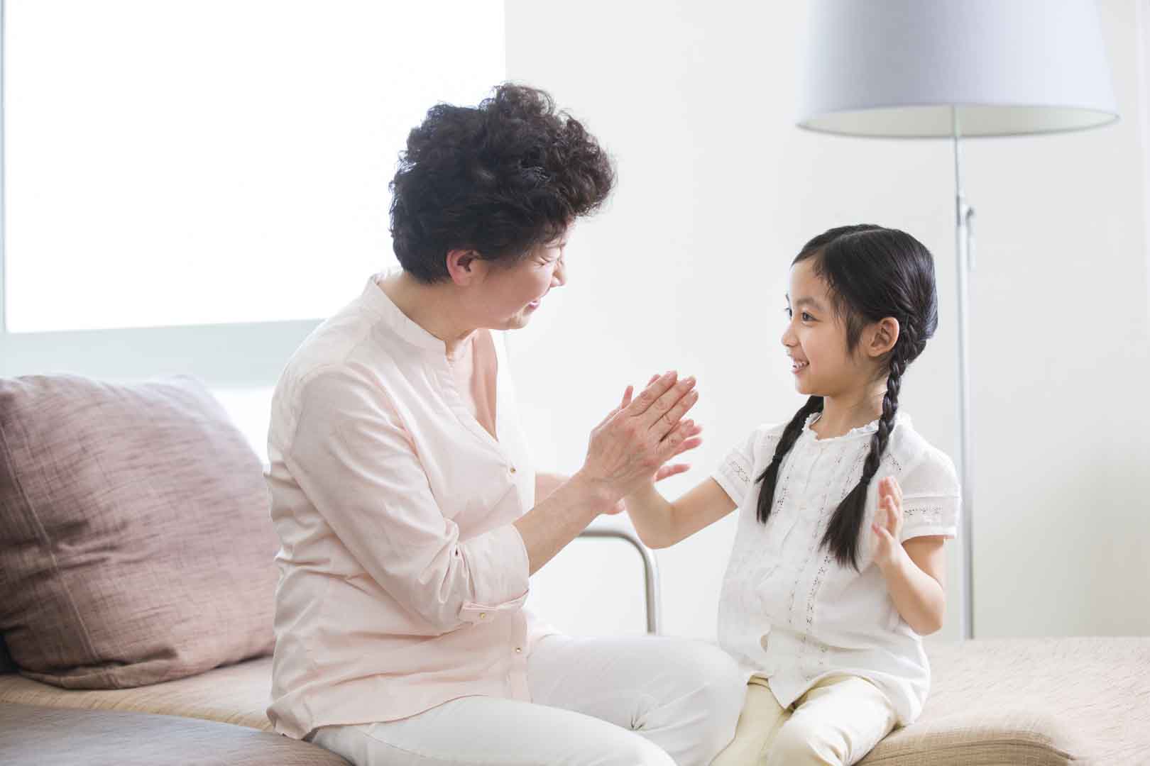 Young girl engaging in play-based speech therapy activities with an adult in a supportive, home-like environment in Phnom Penh